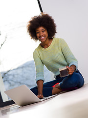 Image showing black woman in the living room on the floor