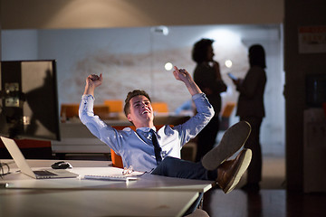 Image showing businessman sitting with legs on desk at office