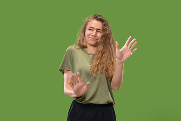 Image showing Let me think. Doubtful pensive woman with thoughtful expression making choice against green background