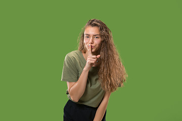 Image showing The young woman whispering a secret behind her hand