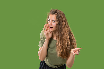 Image showing The young woman whispering a secret behind her hand