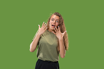 Image showing Beautiful woman looking suprised isolated on green