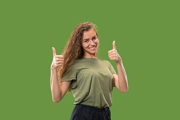 Image showing The happy business woman standing and smiling against green background.