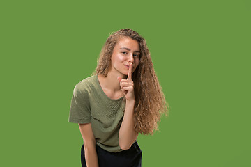 Image showing The young woman whispering a secret behind her hand