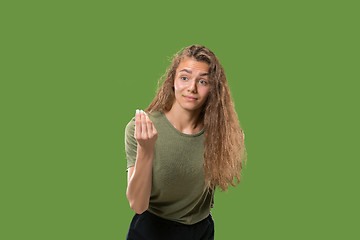 Image showing Beautiful female half-length portrait isolated on green studio backgroud. The young emotional surprised woman