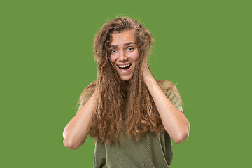 Image showing The happy woman standing and smiling against green background.