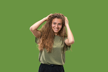 Image showing The happy woman standing and smiling against green background.