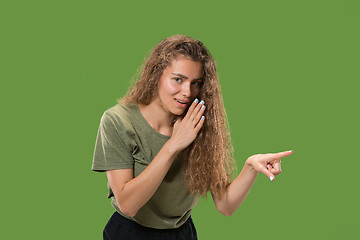 Image showing The young woman whispering a secret behind her hand