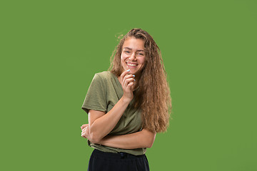 Image showing The happy woman standing and smiling against green background.