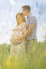 Image showing Young happy pregnant couple hugging in nature.