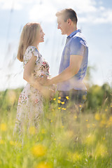 Image showing Young happy pregnant couple hugging in nature.