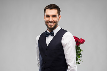 Image showing happy man with red roses behind his back