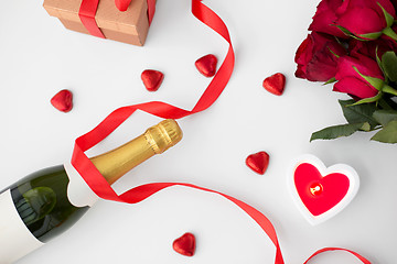 Image showing close up of champagne, gift, candies and red roses