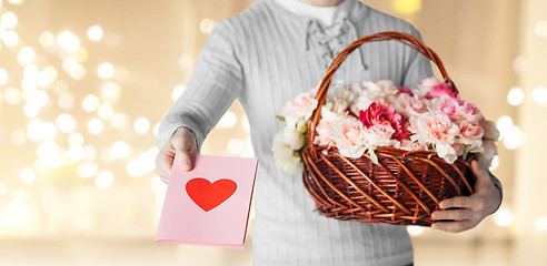 Image showing man holding basket of flowers with greeting card