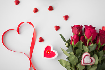 Image showing close up of red roses, candies and candle