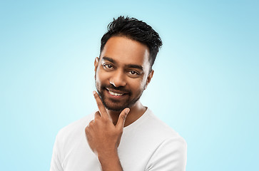 Image showing smiling indian man touching his beard