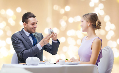 Image showing man photographing woman by camera at restaurant