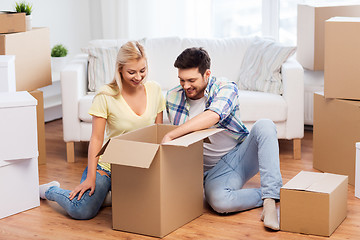 Image showing happy couple unpacking boxes at new home