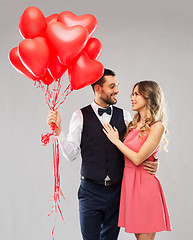 Image showing happy couple with red heart shaped balloons