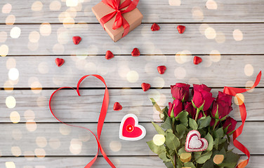 Image showing close up of red roses, gift, candies and candle