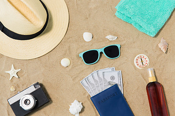 Image showing money in passport, shades and hat on beach sand