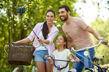 Image showing happy family with bicycles taking selfie in summer