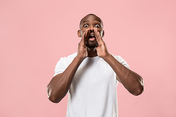 Image showing Isolated on pink young casual man shouting at studio