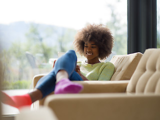 Image showing young african american woman at home using digital tablet