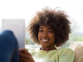 Image showing young african american woman at home using digital tablet