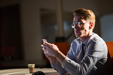 Image showing man using mobile phone in dark office