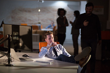 Image showing businessman sitting with legs on desk at office