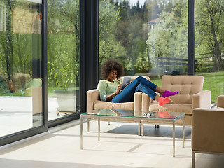 Image showing young african american woman at home using digital tablet