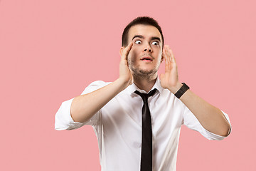 Image showing Isolated on pink young casual man shouting at studio