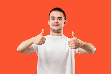 Image showing The happy businessman standing and smiling against red background.