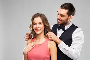 Image showing happy man puts necklace on his girlfriend