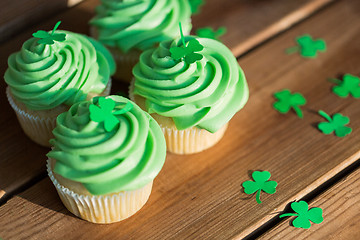 Image showing green cupcakes and shamrock on wooden table