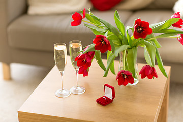 Image showing diamond ring, champagne and flowers on table