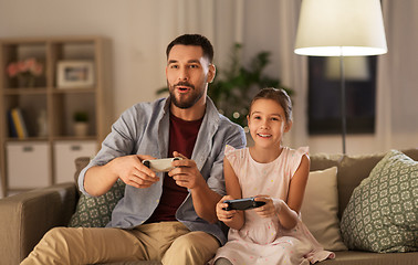 Image showing father and daughter playing video game at home