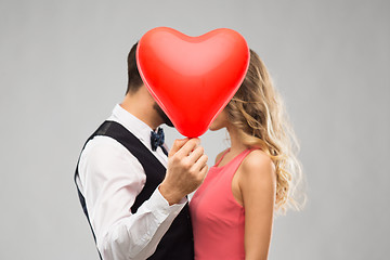 Image showing couple hiding behind red heart shaped balloon