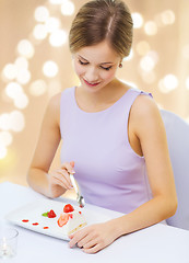 Image showing smiling young woman eating dessert at restaurant