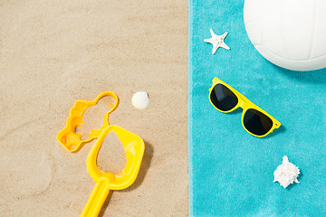 Image showing sunglasses, sand toys and ball on beach towel