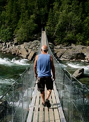 Image showing Man walking on a suspension bridge