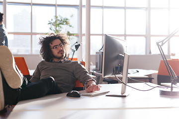 Image showing businessman sitting with legs on desk