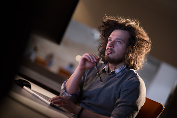 Image showing man working on computer in dark office