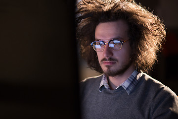 Image showing man working on computer in dark office