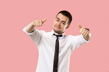 Image showing The happy businessman standing and smiling against pink background.