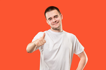 Image showing The happy businessman standing and smiling against red background.