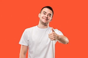 Image showing The happy businessman standing and smiling against red background.