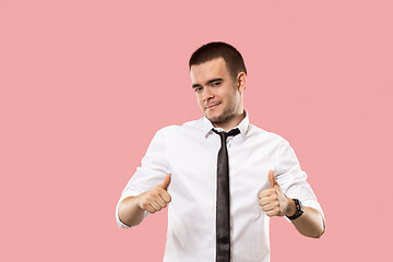 Image showing The happy businessman standing and smiling against pink background.