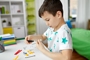 Image showing little boy playing with building kit at home